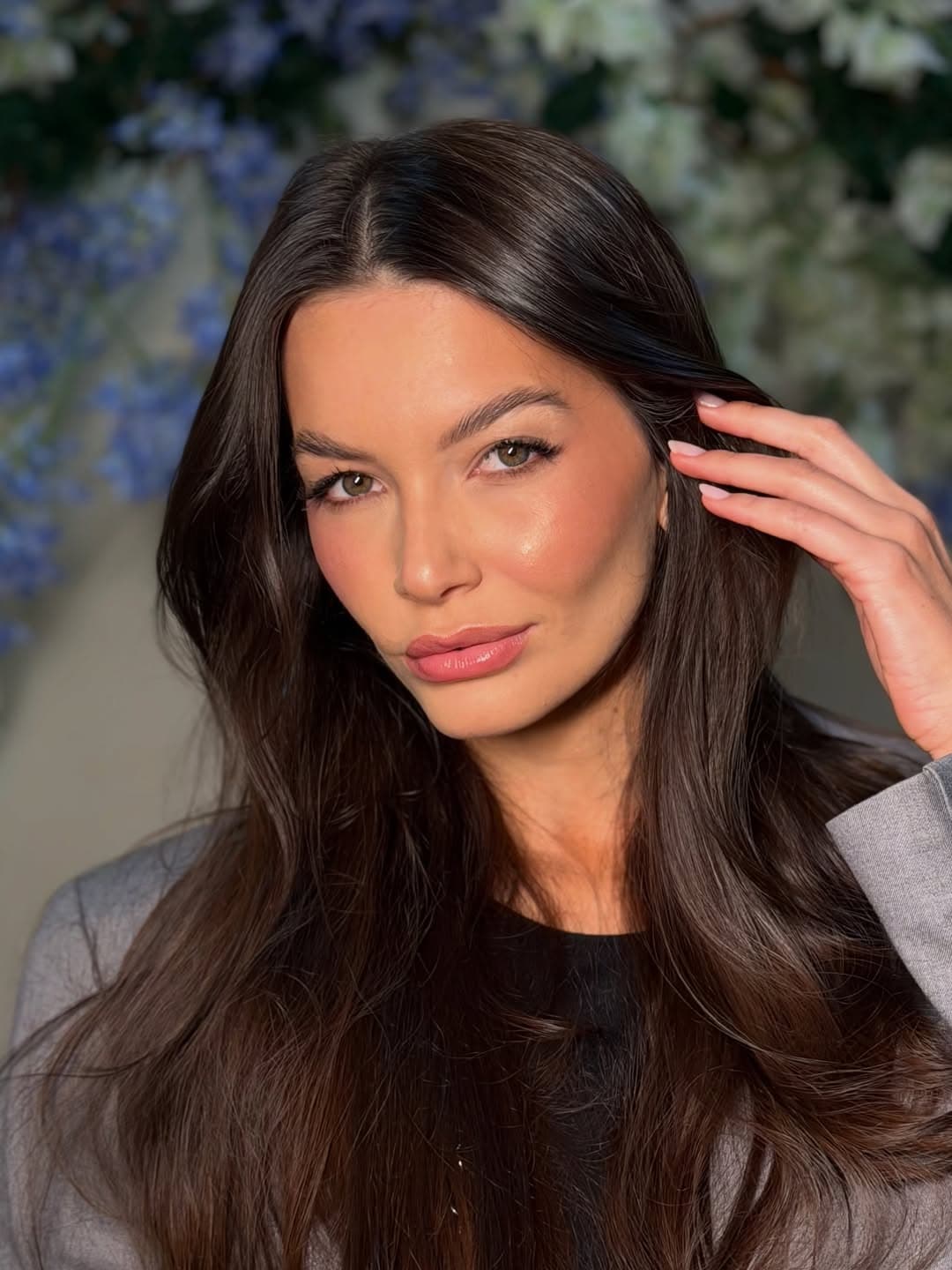 Make por Gaby Arbter em cenário de flores azuis
